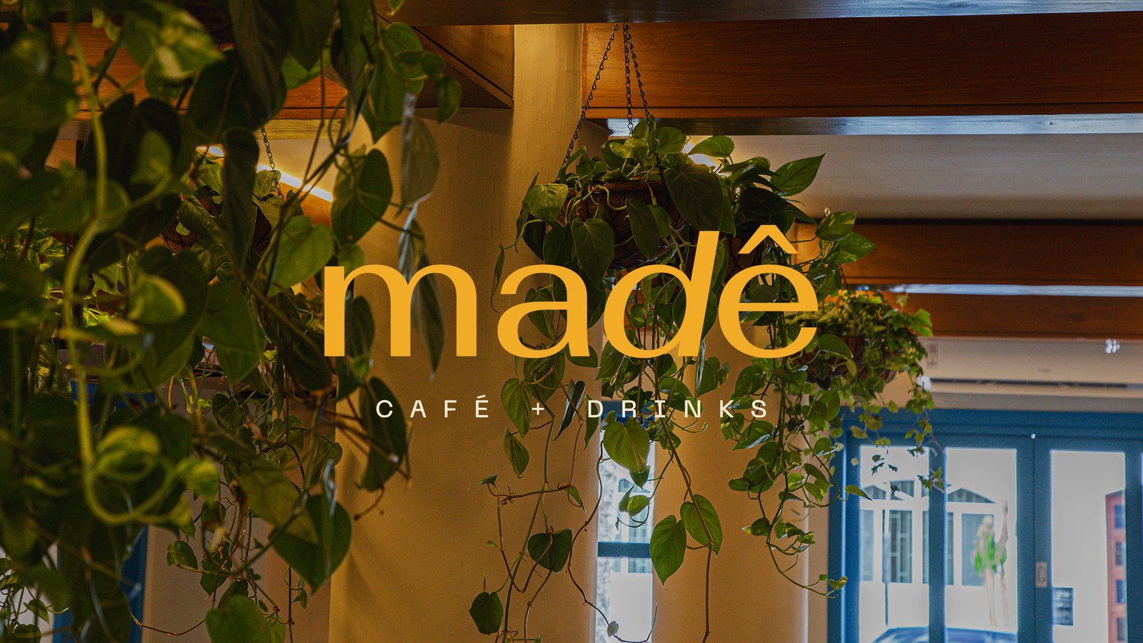 Letreiro da Madê na fachada envidraçada do café