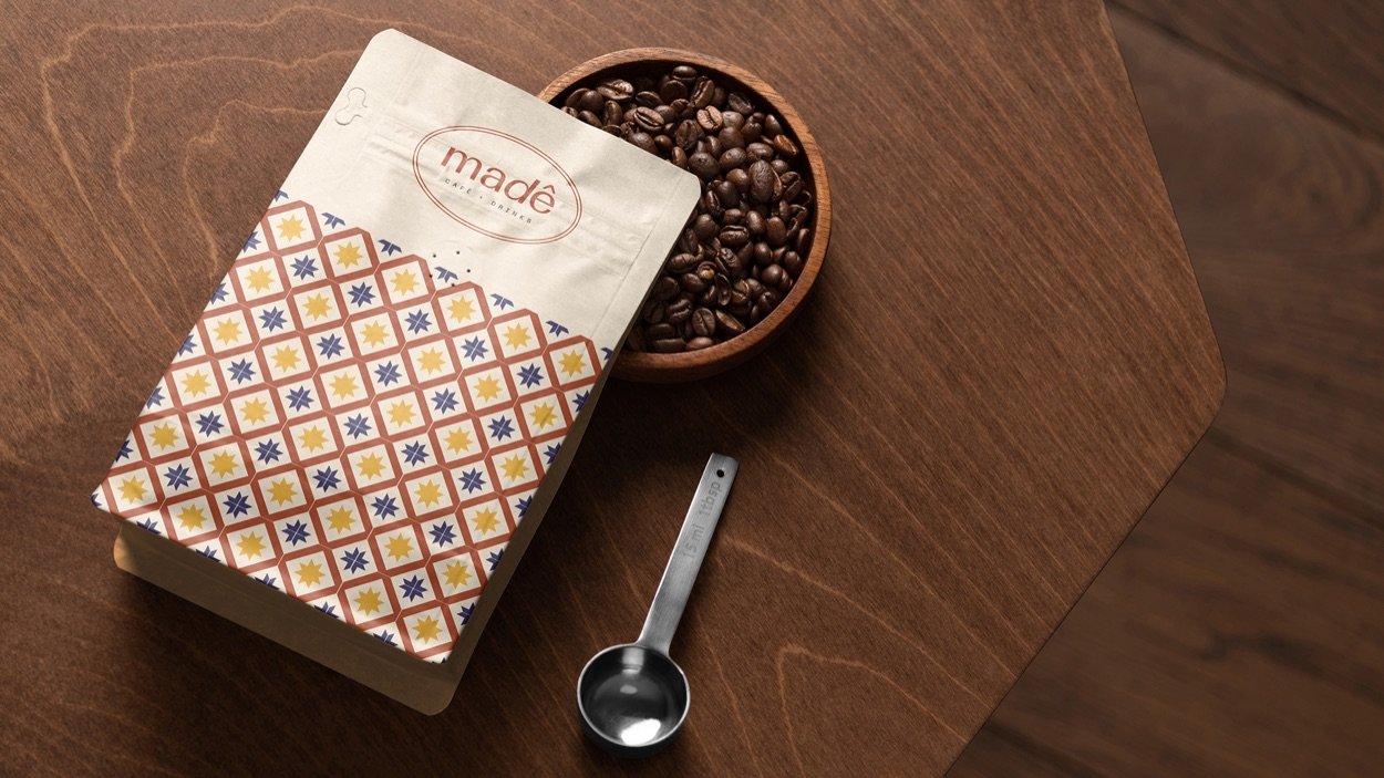 Pacote de café da Madê com grãos e dosador